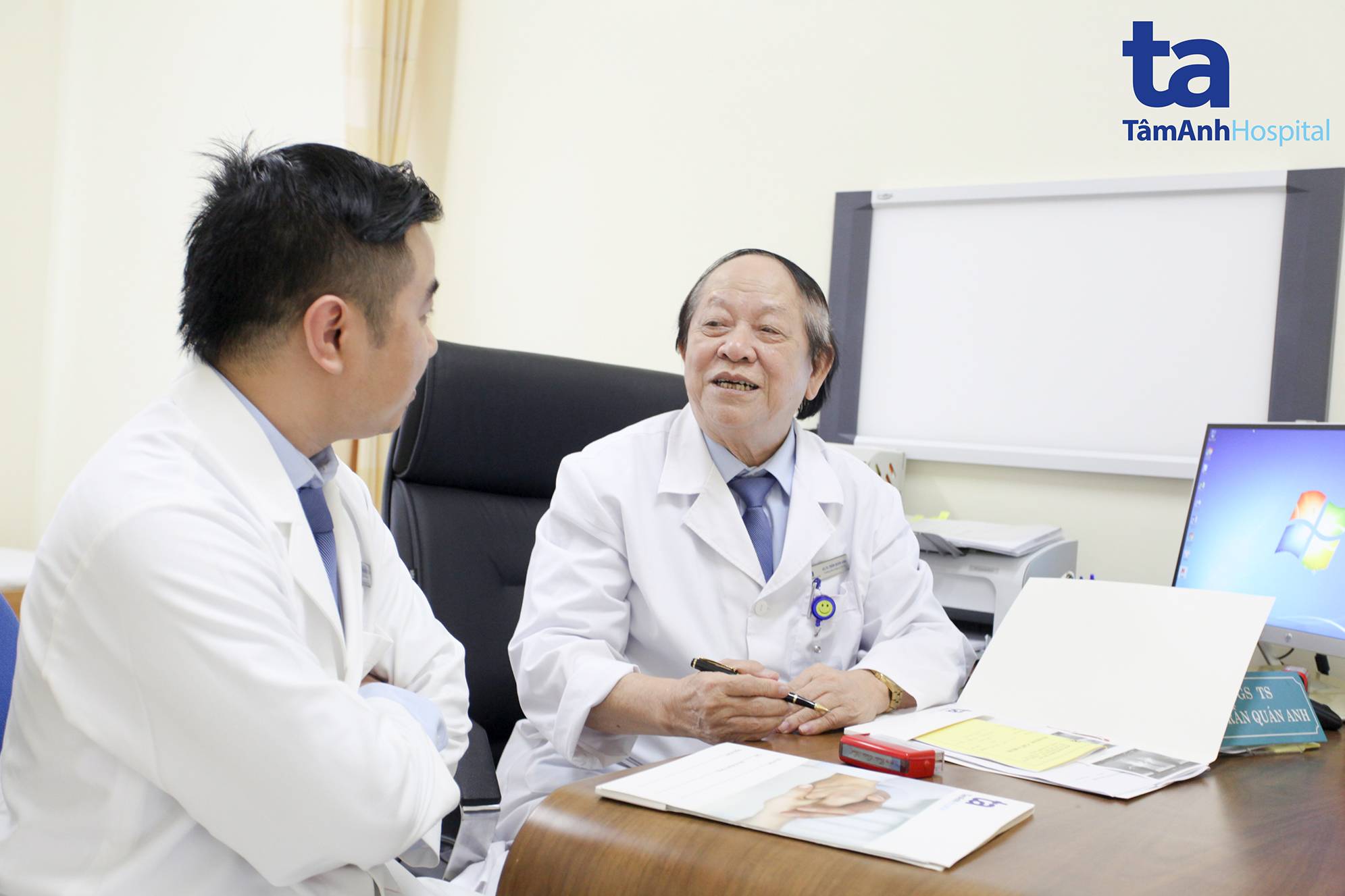 Giáo sư Trần Quán Anh và bác sĩ Nguyễn Ngọc Tân, khoa Tiết niệu - Nam học cùng trao đổi sau khi thăm khám cho bệnh nhân N.V.A
