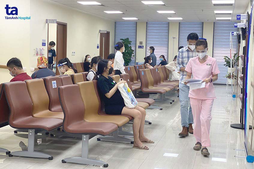 chờ khám sàng lọc trước phòng tiêm vắc xin