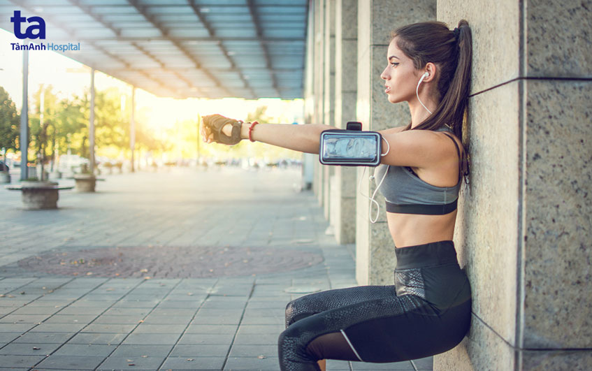 ngồi xổm dựa lưng vào tường