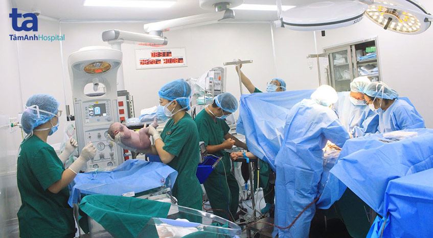 Bé trai được bác sĩ kiểm tra sức khỏe tại phòng mổ