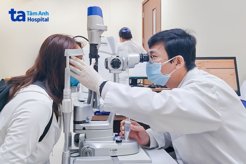 Một bệnh nhân bị đau mắt đỏ đang được bác sĩ Tùng thăm khám
