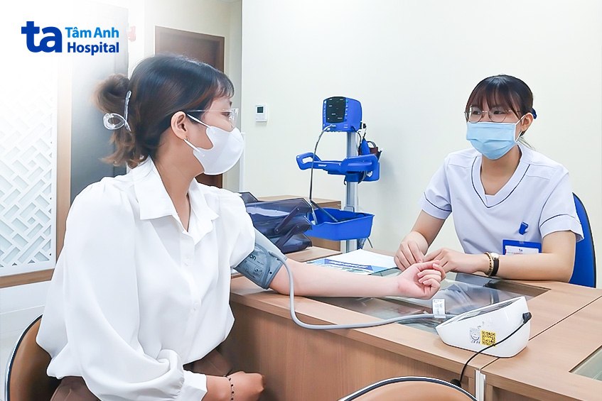 Người bệnh đang được đo huyết áp ở bàn đánh giá ban đầu