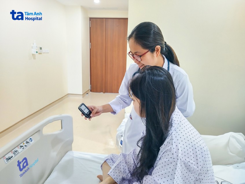 Bác sĩ Trúc hướng dẫn em T. sử dụng máy đo đường huyết
