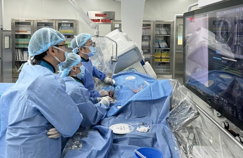 Các bác sĩ đưa stent mới vào đoạn mạch tái hẹp, khơi thông dòng máu nuôi tim cho bệnh nhân
