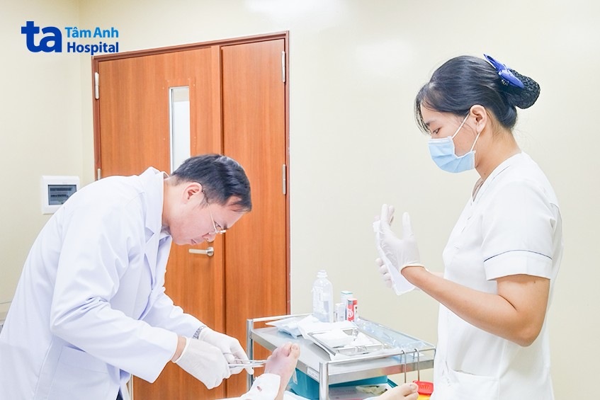 Bác sĩ Nguyên Duy đang chăm sóc vết thương cho bà M