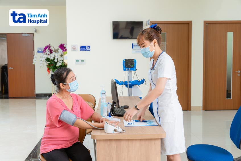 kỹ thuật viên tại bvđk tâm anh hỗ trợ đo huyết áp cho bệnh nhân