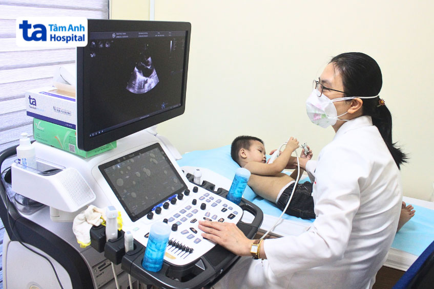 Bác sĩ thực hiện chẩn đoán bằng phương pháp siêu âm tim cho trẻ