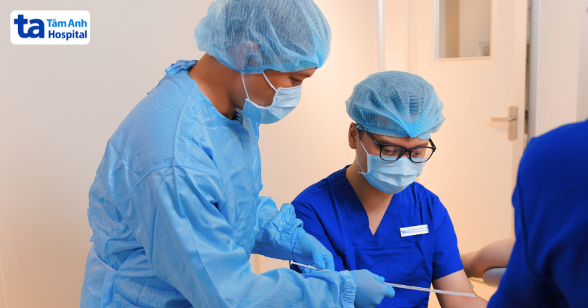 Bác sĩ và chuyên viên phôi học kiểm tra catheter chứa phôi trước khi chuyển