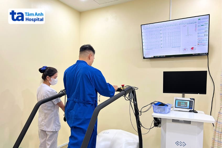 Người bệnh được kỹ thuật viên hỗ trợ thực hiện phương pháp điện tâm đồ