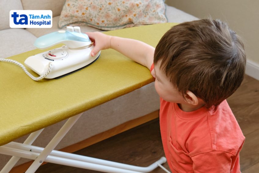 trẻ chạm vào các đồ vật nóng như bàn ủi