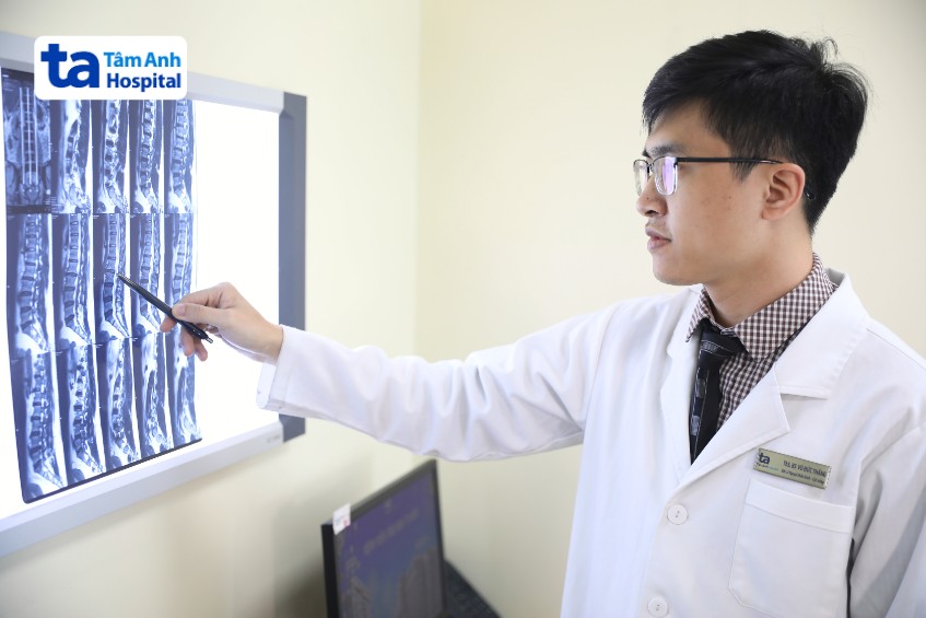 bác sĩ thắng xem xét cột sống bệnh nhân