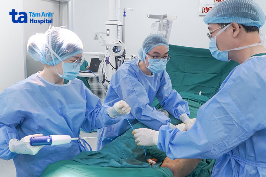Bác sĩ Quyền (ngoài cùng bên phải) cùng êkíp bơm keo sinh học điều trị suy tĩnh mạch chi dưới cho anh Tấn