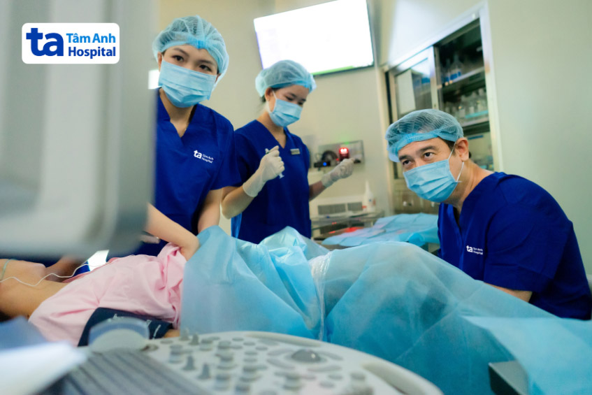 Bác sĩ Tuân (ngồi) đang chọc hút trứng cho chị Hồng. Ảnh: Bệnh viện Đa khoa Tâm Anh - Quận 8