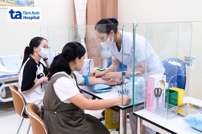 nhân viên điều dưỡng thực hiện lấy máu