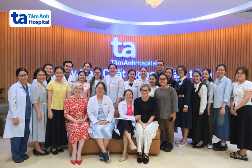 Các bác sĩ, chuyên gia, chuyên viên phôi học và nhân viên y tế chụp hình lưu niệm cùng hai chuyên gia