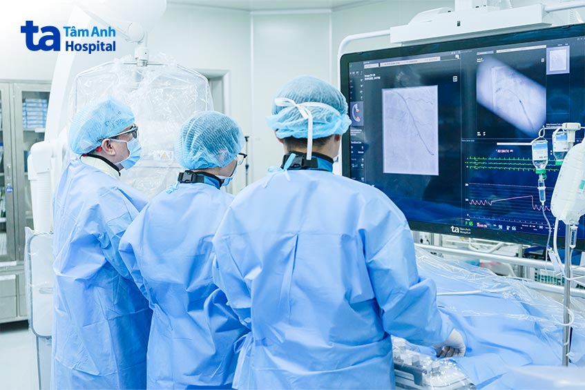 Giáo sư Nhân (bên trái) cùng êkíp bác sĩ tiến hành đặt stent cho người bệnh