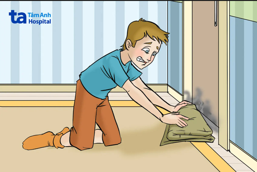 dùng khăn ướt che kín khe cửa để ngăn khói