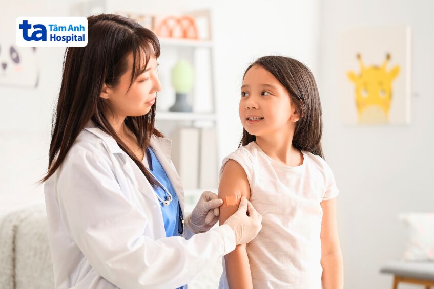 bác sĩ dán băng gạc sau tiêm cho trẻ