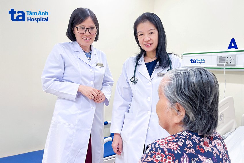 Bác sĩ Bình (trái) và bác sĩ Kiều hỏi thăm tình trạng cụ bà trước lúc xuất viện