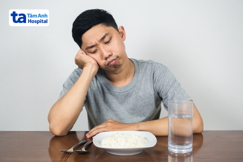 Người đàn ông nhìn bát cơm với vẻ chán ăn, biểu cảm liên quan chế độ ăn kiêng