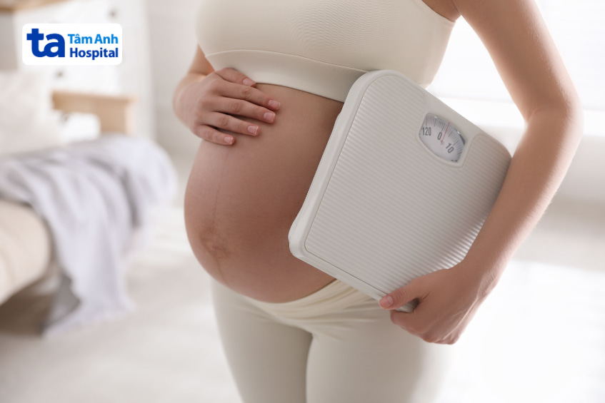 Bà bầu cầm cân theo dõi sức khỏe và kiểm soát dinh dưỡng trong thai kỳ