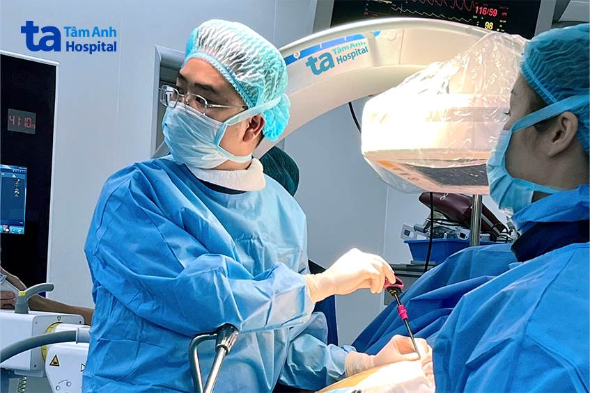 bác sĩ bơm xi măng sinh học cho bệnh nhân