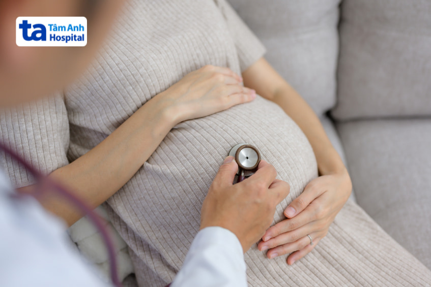 Bác sĩ dùng ống nghe kiểm tra thai nhi cho bà bầu trong bệnh viện Tâm Anh