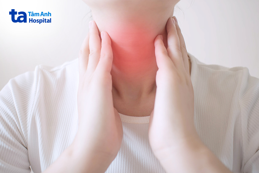 Người phụ nữ dùng tay chạm vùng cổ đỏ biểu hiện triệu chứng tuyến giáp bất thường