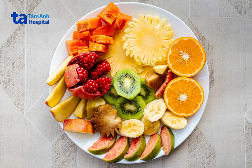 Đĩa trái cây tươi gồm dứa, cam, ổi, lựu, chuối... phù hợp cho chế độ dinh dưỡng thai kỳ