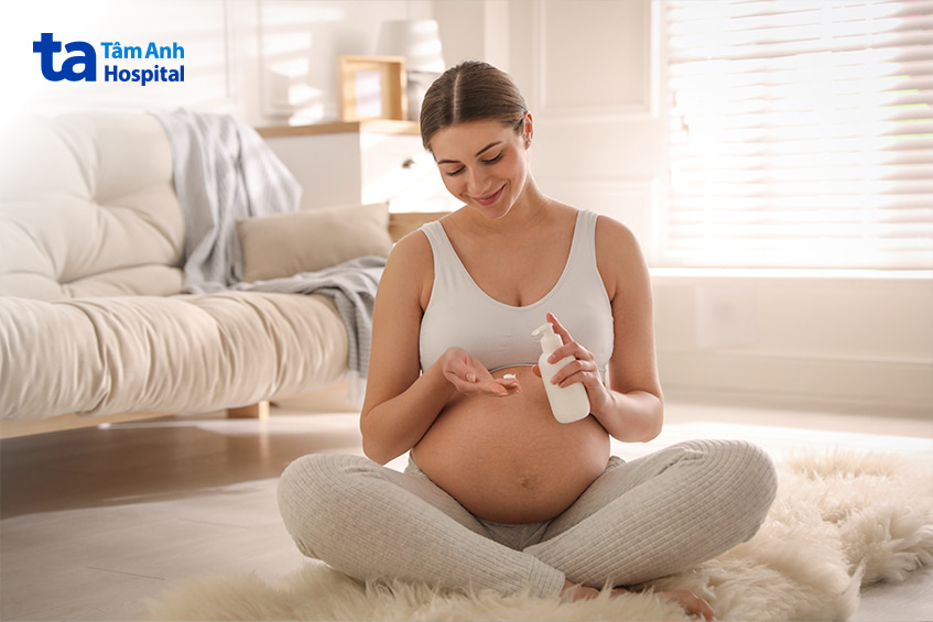 Bà bầu ngồi thoải mái chuẩn bị thoa kem điều trị trĩ an toàn trong thai kỳ