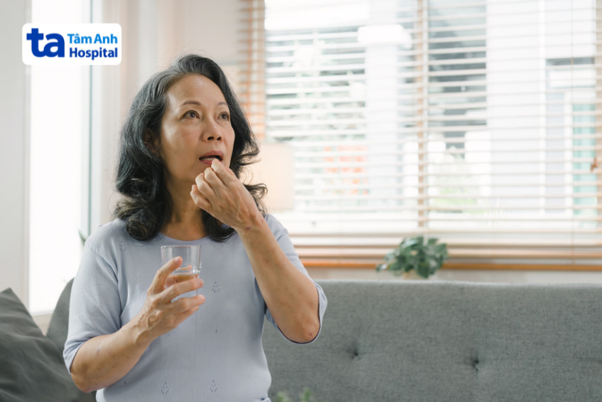 Người phụ nữ trung niên uống thuốc tại nhà – minh họa việc sử dụng empagliflozin