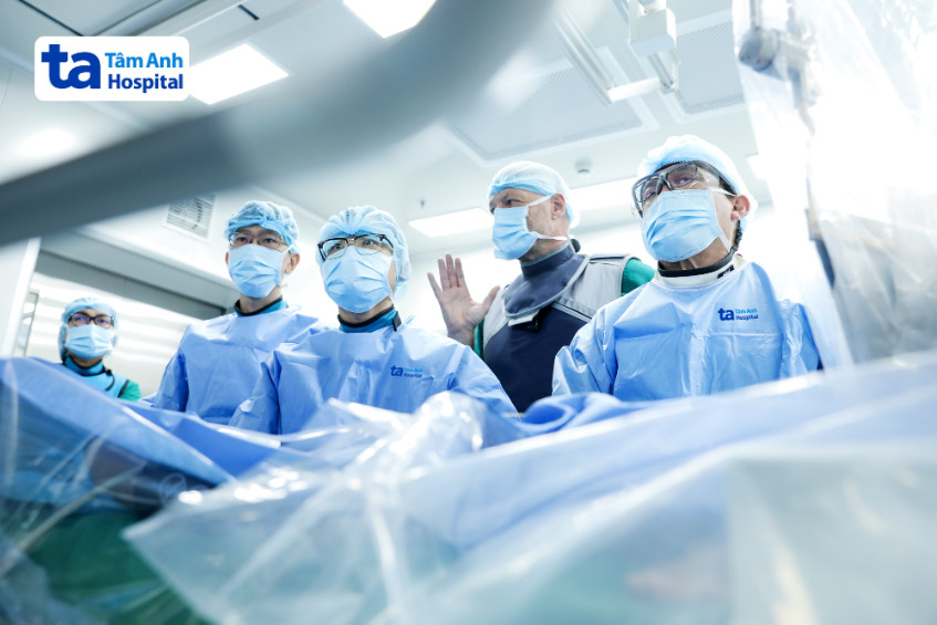 GS.TS.BS Võ Thành Nhân (ngoài cùng bên phải) và ekip thực hiện thay van động mạch chủ qua ống thông cho người bệnh với sự tư vấn của GS Markus Kasel (thứ 2 phải qua), Trưởng khoa Can thiệp tim cấu trúc, Bệnh viện Đại học Zurich, Thụy Sĩ