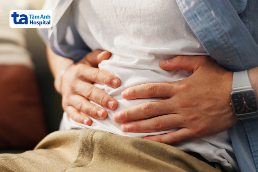 Nam giới ôm bụng đau, biểu hiện tình trạng đầy hơi hoặc rối loạn tiêu hóa.