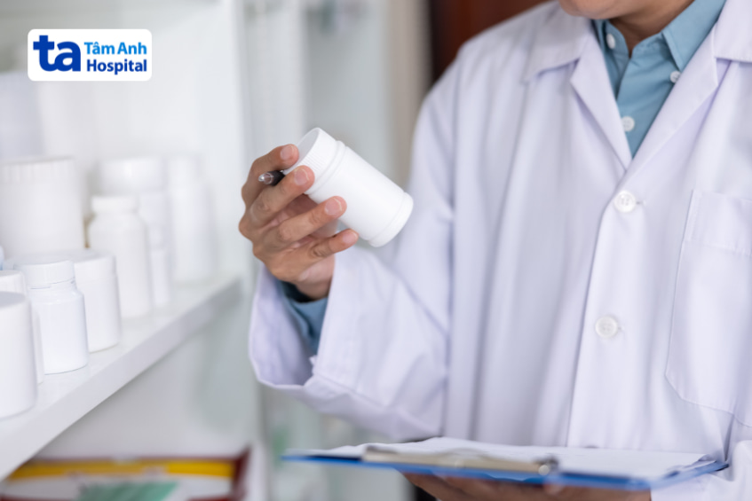 Dược sĩ kiểm tra lọ thuốc trắng trong nhà thuốc bệnh viện Tâm Anh