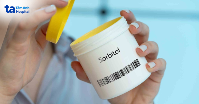 Hộp nhựa trắng chứa sorbitol được mở nắp, trên tay người sử dụng