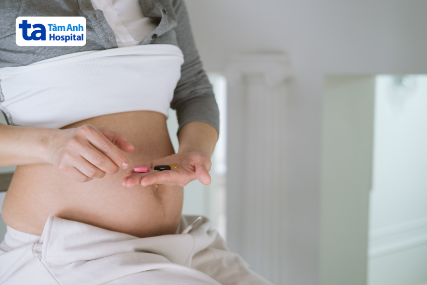 Phụ nữ mang thai đang cầm viên thuốc, cần cân nhắc khi sử dụng thuốc an thần
