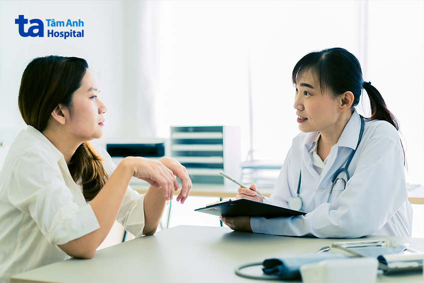 Bệnh nhân nữ đang trao đổi với bác sĩ về triệu chứng lòi dom trong phòng khám