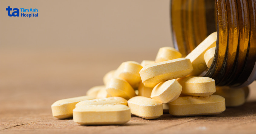 Hình ảnh viên thuốc màu vàng đổ ra từ lọ, minh họa thuốc sultamicillin dùng trong điều trị nhiễm khuẩn