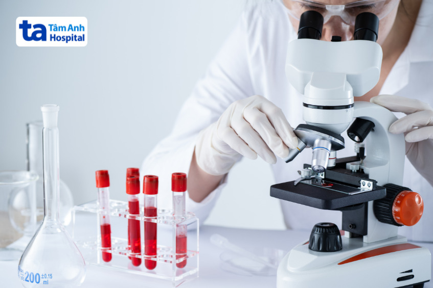 bác sĩ đang soi kính hiển vi để đánh giá mẫu máu