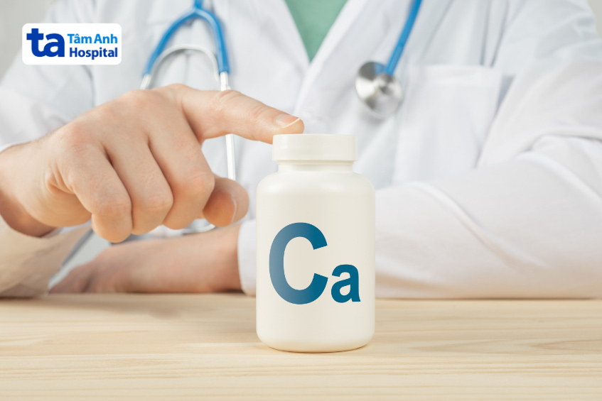 Bác sĩ chỉ tay vào lọ canxi, biểu tượng Ca, minh họa việc bổ sung canxi trong y tế