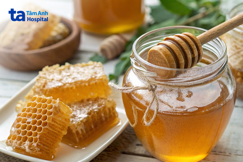 Hũ mật ong nguyên chất và sáp ong trên bàn gỗ, dùng minh họa thực phẩm tự nhiên