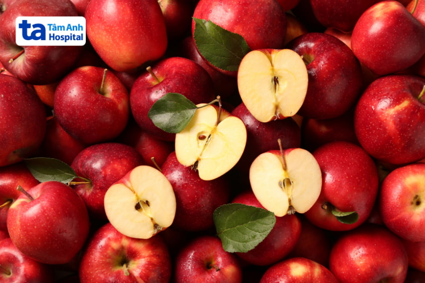Táo đỏ nguyên trái và bổ đôi, giàu chất xơ hỗ trợ tiêu hóa cho người bị sỏi mật