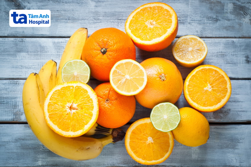 Nhiều loại trái cây giàu vitamin gồm cam, chuối, chanh, bưởi trên bàn.