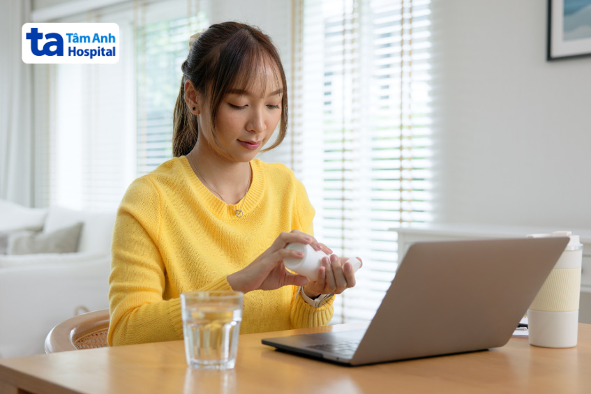 Người phụ nữ chuẩn bị uống thuốc Ezetimibe hỗ trợ điều trị rối loạn lipid máu