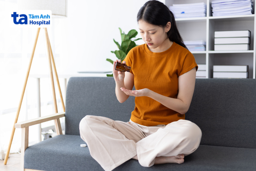 Phụ nữ đang chuẩn bị uống tramadol để giảm đau tại nhà