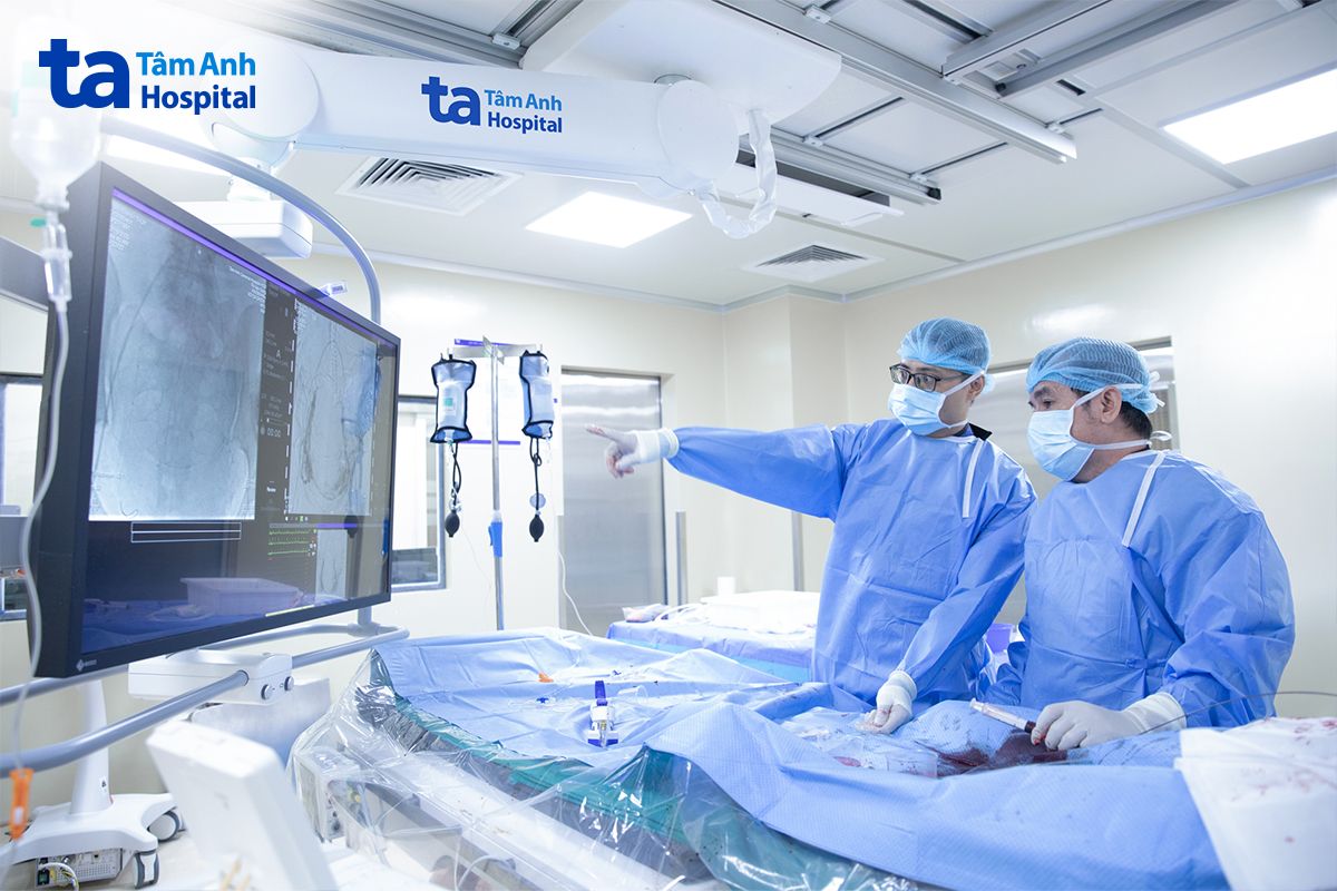 bác sĩ đang xem hình ảnh phẫu thuật dưới hướng dẫn của hệ thống hình ảnh hiện đại