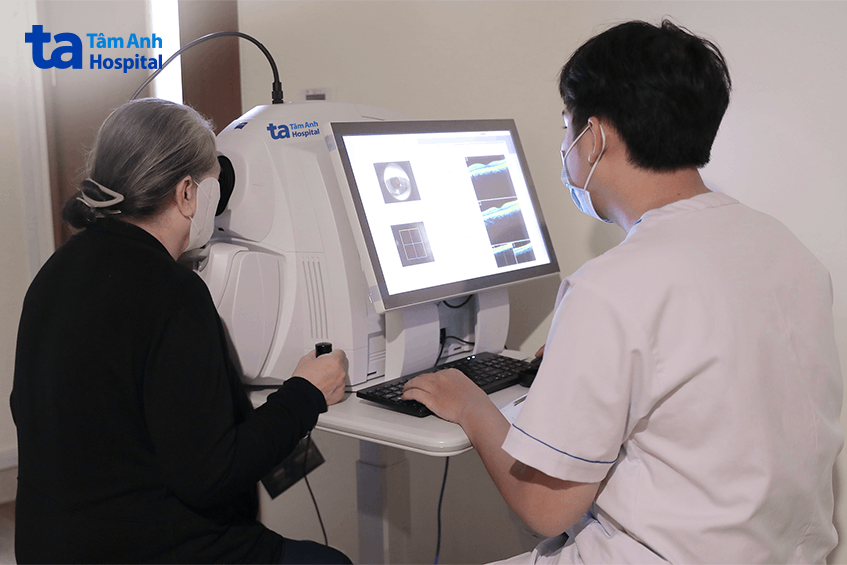 Kỹ thuật viên tắt đèn khi thực hiện chụp cắt lớp quang học, kiểm tra cấu trúc vi mô mắt cho bà Mai. Ảnh: Bệnh viện Đa khoa Tâm Anh