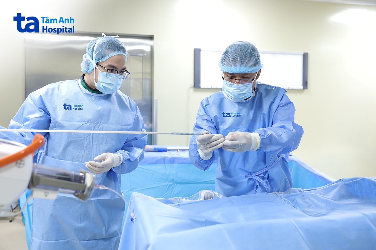 Phó giáo sư Vĩnh (bên phải) cùng êkíp chuẩn bị đặt stent graft cho người bệnh