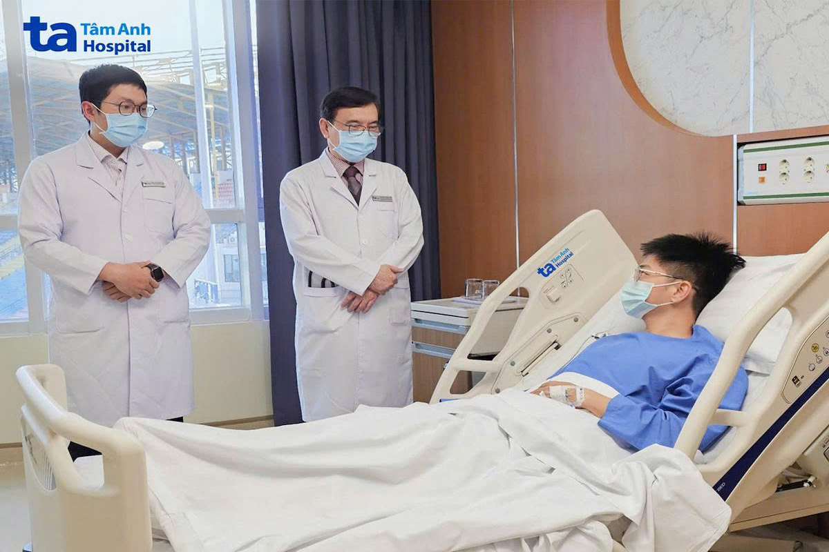 Giáo sư Nhân (giữa) hỏi thăm sức khỏe bệnh nhân sau thủ thuật
