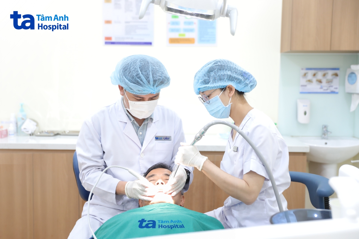 Bác sĩ Vũ Thành Đạt xử lý cặp răng tổn thương cho người bệnh.
